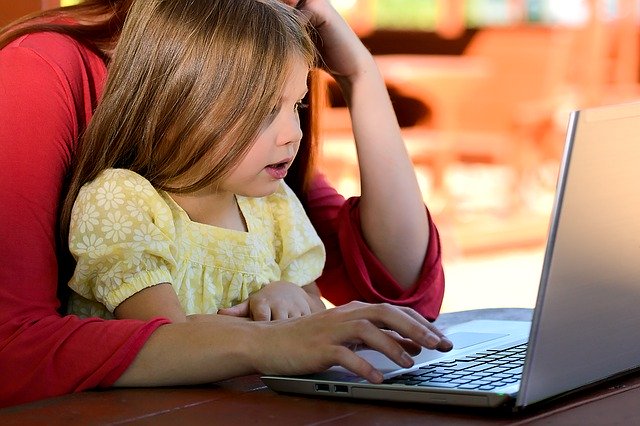 holčička sedící s matkou u počítače